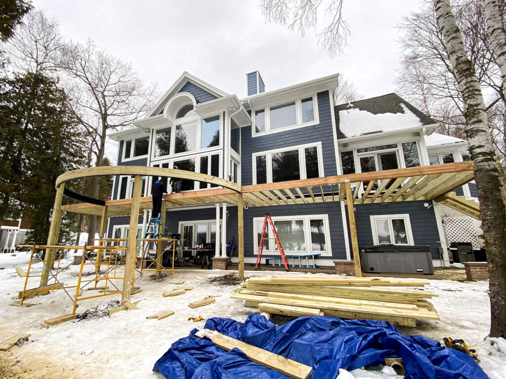 A new second story decking being installed in the winter with the deck frame partially installed.